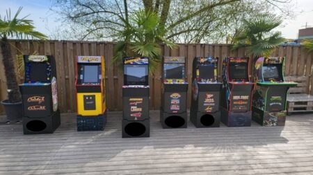 7 arcade automaten aufgereiht auf einer terasse