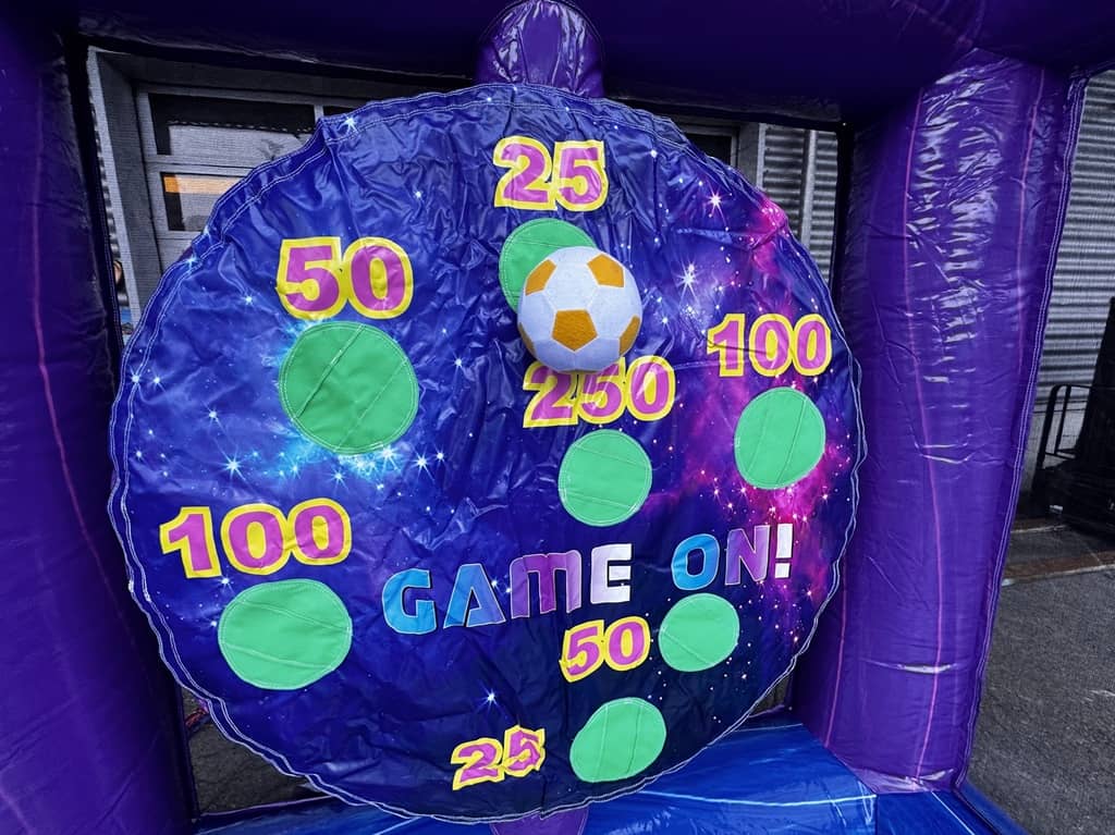 zielscheibe rund aus plastik mit diversen zahlen. hier höngt ein klett fussball an der 25