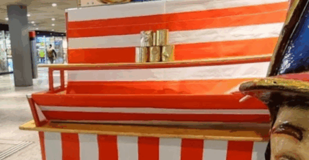 rot weiss gestreiftes gestell mit 5 goldenen dosen zum abwefen