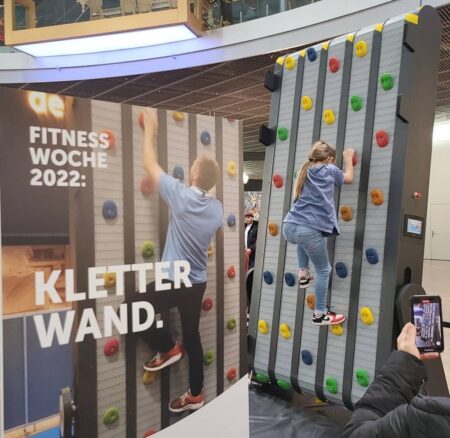 mobile kletterwand in einem einkaufszentrum. ein kleines kind klettert and dieser.