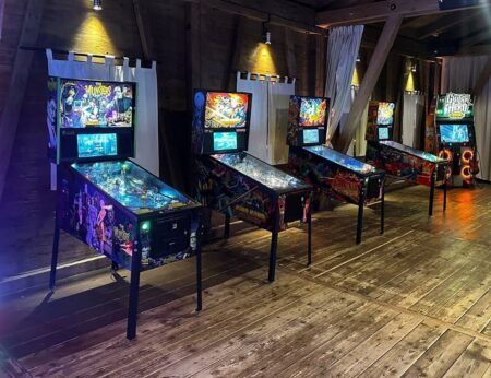 4 moderne schön bunt beleuchtete Flipperkasten nebeneinander in einer urigen Location...