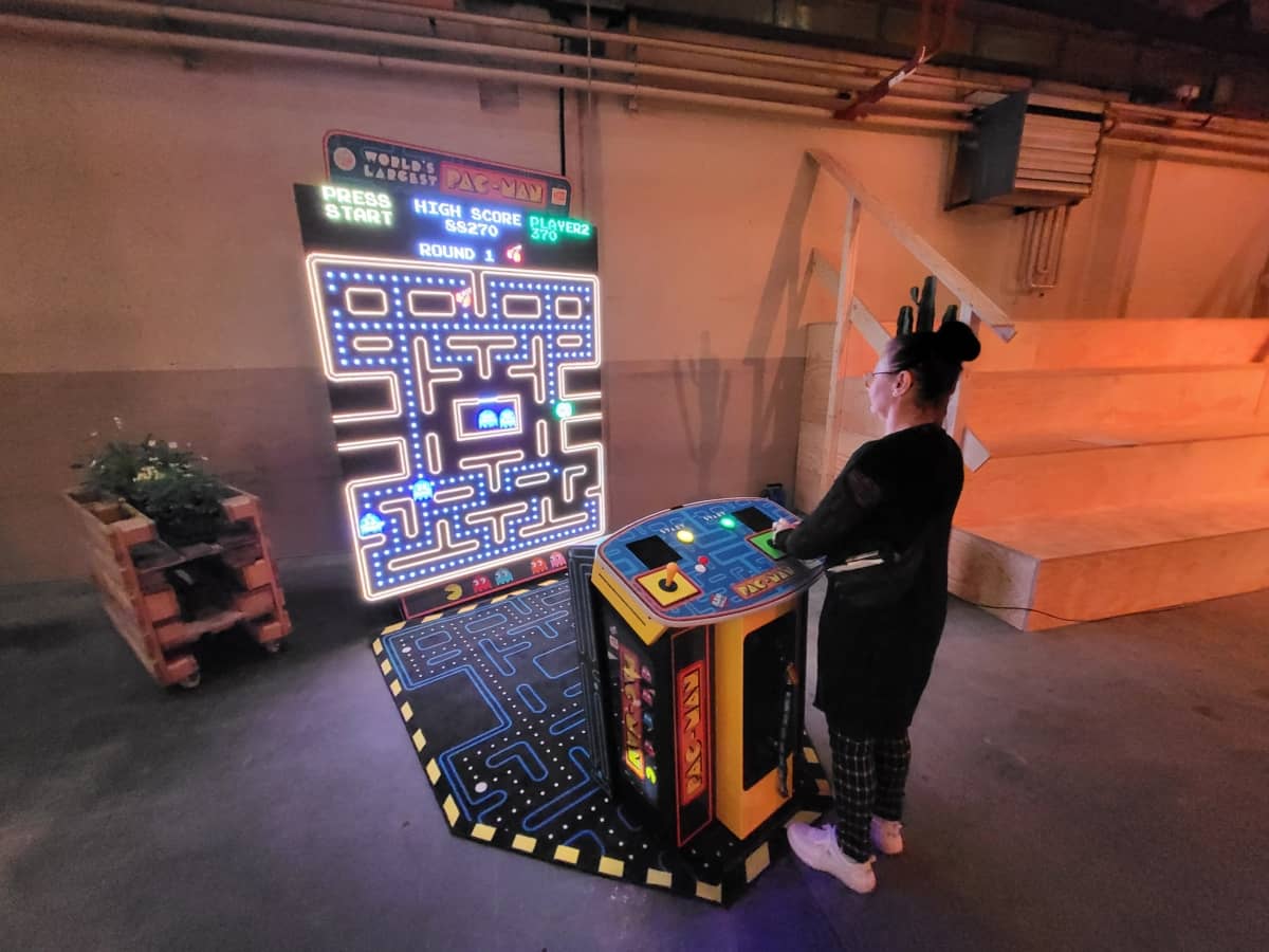 Eine Frau spielt am XXL Pac-Man-Automat.