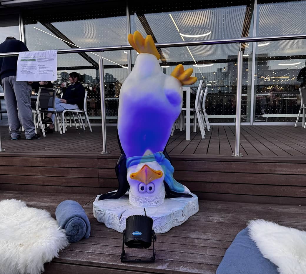 lustiger comic pinguin aus kunststoff welcher auf dem kopf steht.