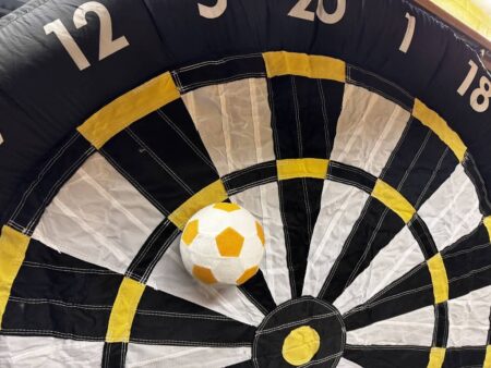 teil einer aufblasbaren reisen dartscheibe. ein weiss gelber ball klettet an der nummer 12.