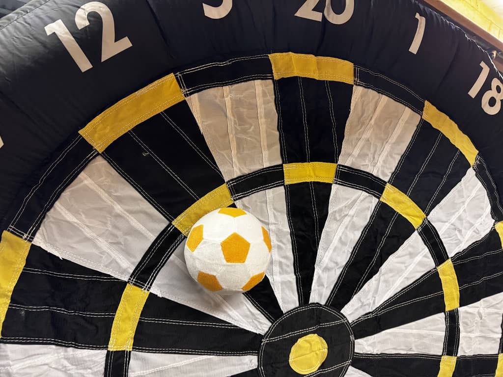 teil einer aufblasbaren reisen dartscheibe. ein weiss gelber ball klettet an der nummer 12.