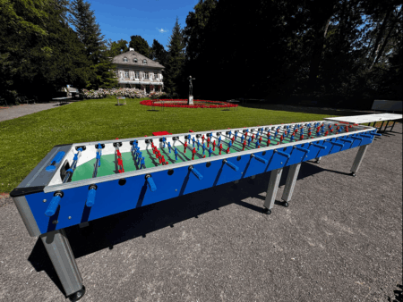 tischkicker für 14 personen in einem schönen garten vor einem schloss
