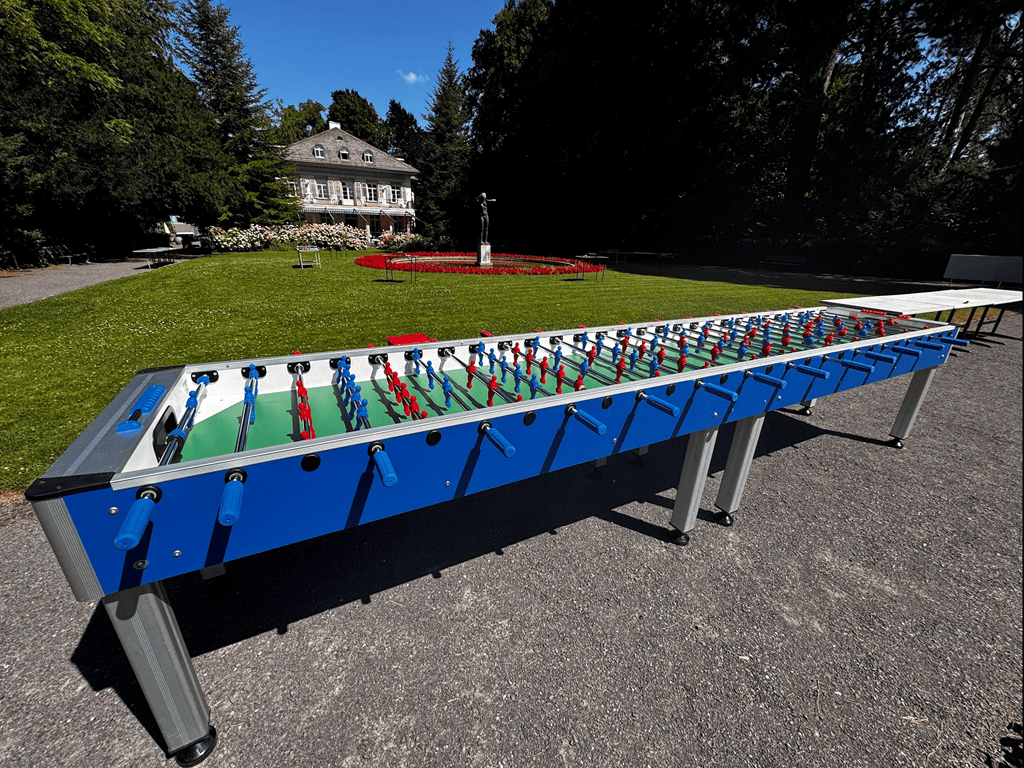 tischkicker für 14 personen in einem schönen garten vor einem schloss